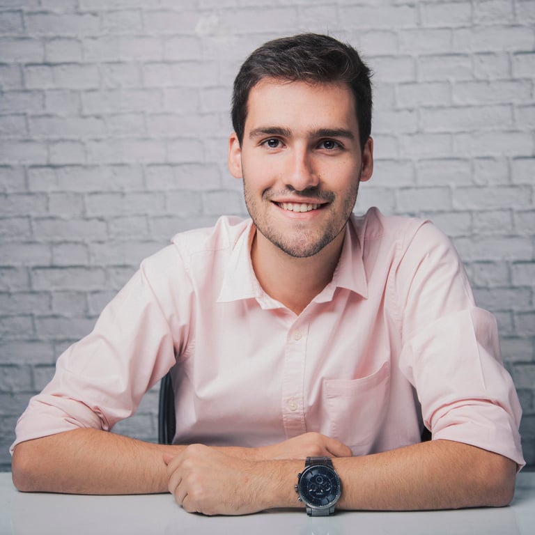 Smiling man sitting at table and crossing arms